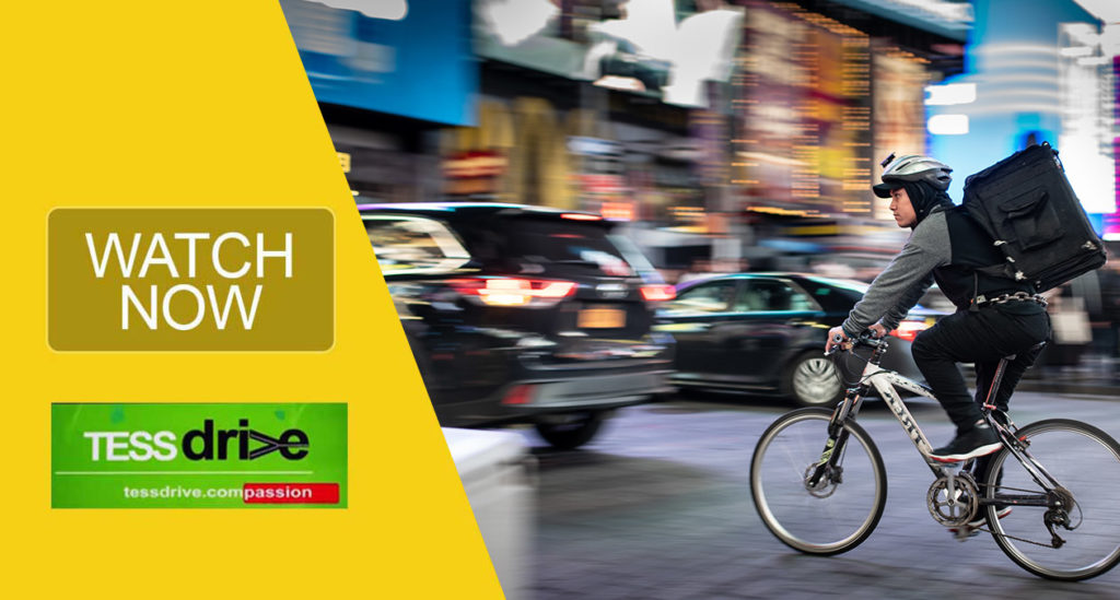 Man riding a biycle on a busy street